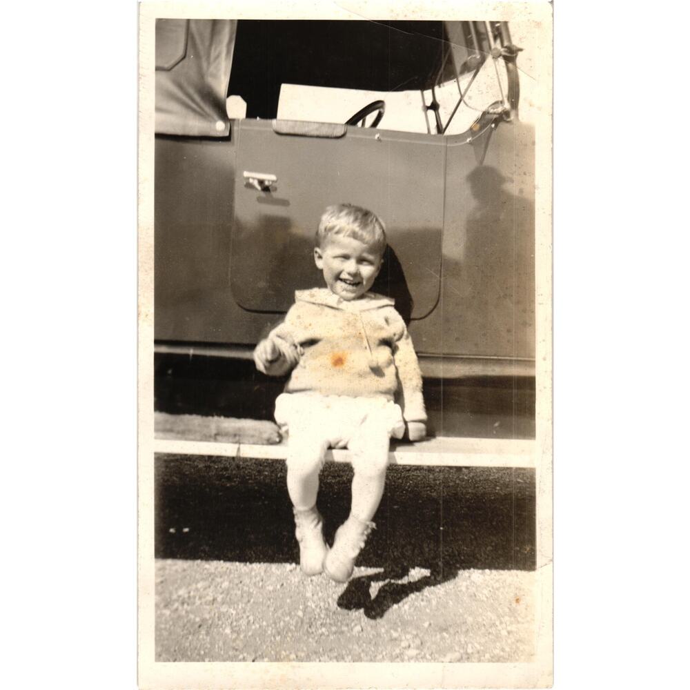 Vintage Snapshot Child Sitting on Running Board of Early Car Smiling‎ Photo